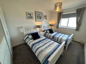 a bedroom with two beds and a window at Seapoint House in Cleveleys