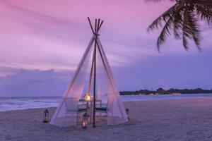 a table in a tent on the beach at Malahini Kuda Bandos Resort in North Male Atoll