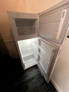 un frigorifero vuoto con la porta aperta in una stanza di Agréable maison de ville dans la plus belle Avenue a Orléans