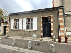 een gebouw met een zwarte deur en twee ramen bij Agréable maison de ville dans la plus belle Avenue in Orléans