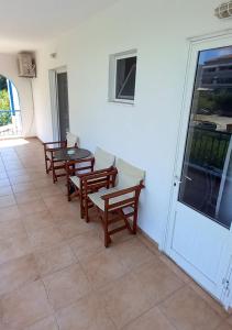 a patio with benches and a table and a door at Glaros Studios in Loutra Edipsou