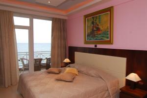 a bedroom with a bed with a view of the ocean at Panorama Hotel in Paralia Katerinis