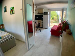 a living room with a red couch and a mirror at Gîte Anse Coco Luberon - Au calme, gite avec piscine securisee in Pertuis