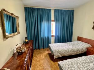 a bedroom with two beds and blue curtains at Alma In the heart of the Vilaflor! Self check in 24h in Vilaflor