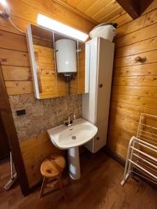 a bathroom with a sink and a refrigerator at Chalet calme cosy Eyne station 2600 in Eyne