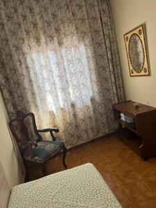 a room with a chair and a curtain and a table at Alma In the heart of the Vilaflor! Self check in 24h in Vilaflor
