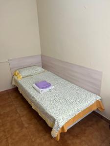 a small bed in a room with a purple pillow on it at Alma In the heart of the Vilaflor! Self check in 24h in Vilaflor