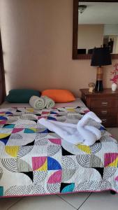 a bed with a colorful quilt and towels on it at apartamento 407 zona 9 in Guatemala