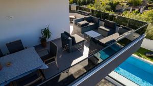 a balcony with a table and chairs and a pool at Villa Porta Salonae in Solin