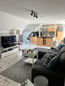 a living room with a couch and a tv at Ankerplatz Güby in Güby