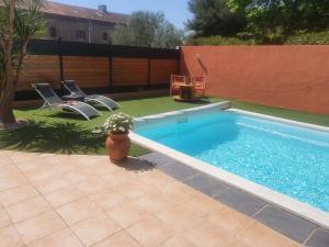 a pool with chairs and a vase of flowers next to it at La Salamandre de Camargue in Salin-de-Giraud