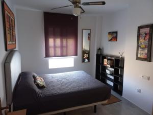 een slaapkamer met een bed en een raam bij Casa Gran Tropicana playa a 2 minutos. in Almuñécar