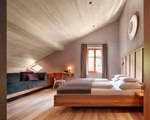 a bedroom with a large bed and a couch at Hotel Gasthof Adler in Schoppernau