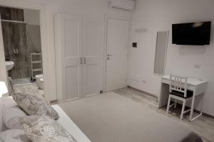 uma sala de estar com um sofá, uma secretária e uma televisão em Central Guest House em Civitavecchia