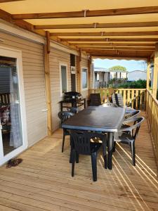 a patio with a table and chairs on a deck at Mobilhome camping le BOSC in Saint-Cyprien