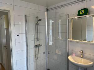 La salle de bains est pourvue d'une douche et d'un lavabo. dans l'établissement Vadstena centrum, à Vadstena