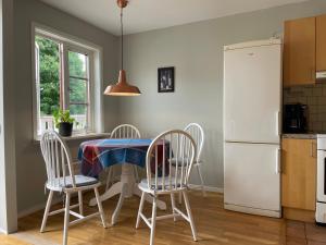 La cuisine est équipée d'une table, de chaises et d'un réfrigérateur. dans l'établissement Vadstena centrum, à Vadstena