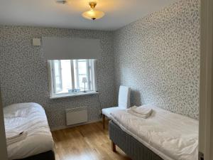 a bedroom with two twin beds and a window at Vadstena centrum in Vadstena