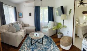 a living room with a couch and a table at Hummingbirds Cabins in Caye Caulker