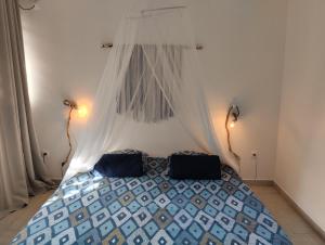 a bedroom with a bed with a mosquito net at Résidence Bois Flotté in Sainte-Anne