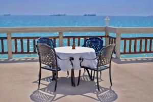 a table and chairs with the ocean in the background at Royal Cliff Zanzibar in Zanzibar City