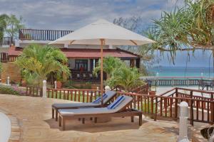 a patio with a chair and an umbrella at Royal Cliff Zanzibar in Zanzibar City