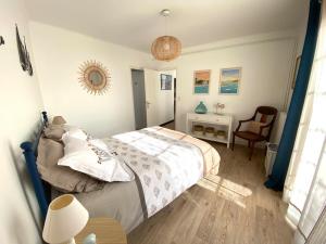 a bedroom with a bed and a table and a chair at Ty Gavrinis - T2- Centre Bourg - 100m de la mer in Larmor-Baden