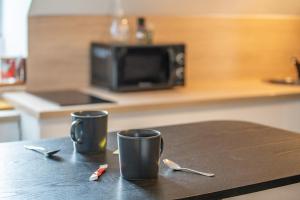 two cups sitting on a table in a kitchen at LE ARA - Gare - centre ville - By Nid'Ouest in Quimper