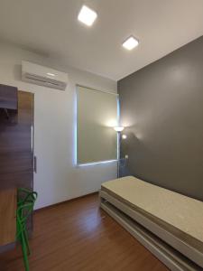 a room with a bed and a window and a projector at Mint Cabin @ Oasis Condo Ipoh in Ipoh