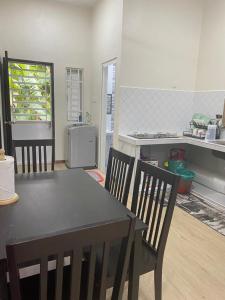 una cucina con tavolo e sedie in una stanza di Ainaz Homestay Balik Pulau a Balik Pulau