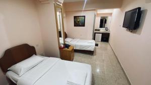 a hotel room with a bed and a television at ALMajd Hotel in Ibri