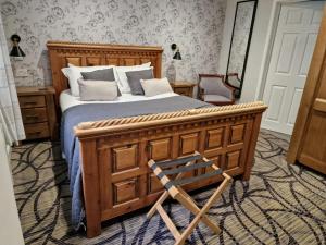 sypialnia z drewnianym łóżkiem i drewnianym krzesłem w obiekcie Country Retreat at Judd's Folly w mieście Faversham