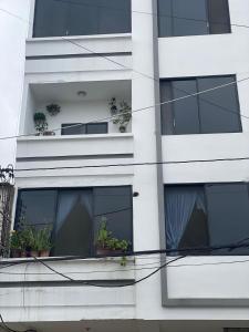 a white building with potted plants on a balcony at Departamento amoblado centro Manta in Manta