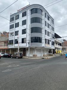 a large white building on the corner of a street at Departamento amoblado centro Manta in Manta