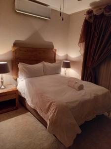 アピントンにあるRiverVio Bed & Breakfastのベッドルーム(白い大型ベッド、ランプ2つ付)