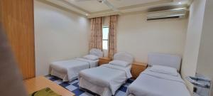 a hospital room with three beds and a window at ALMajd Hotel in ‘Ibrī