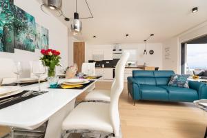 Una cocina y una sala de estar con una mesa y un sofá azul. en Sun Residence Krk, en Krk