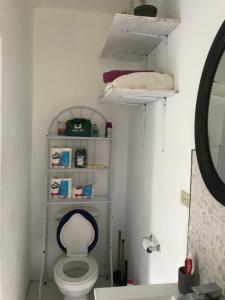 a bathroom with a toilet with a shelf above it at June’s comfort paradise in Runaway Bay