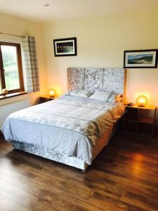 a bedroom with a large bed and two lamps at Coby's Corner, Darney Rd Bruckless in Bruckless