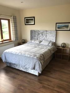 a bedroom with a large bed and a window at Coby's Corner, Darney Rd Bruckless in Bruckless