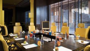 a meeting room with a long table and yellow chairs at Hotel Indigo Bali Seminyak Beach by IHG in Seminyak +237 photos