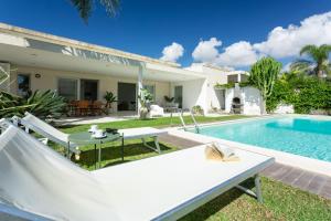 une villa avec une piscine et une maison dans l'établissement paradise island, à Marina di Ragusa