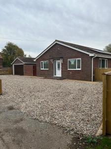 a brick house with a large gravel driveway at The Poplars in Bridlington