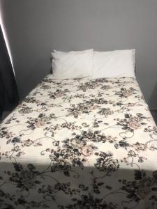 Una cama con un edredón de flores. en PRAIA DO FORTE, en Cabo Frío