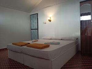a bedroom with a bed with two towels on it at Arya Cottages in Agonda
