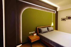 a bedroom with a bed with a green wall at 619Villa in Tainan