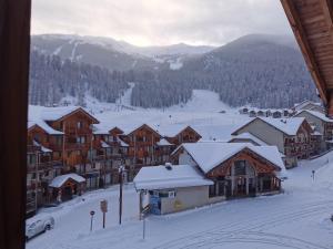 a ski lodge with snow on the roofs at Appartement 4 personnes Les Orres 1800 au pied des pistes in Les Orres