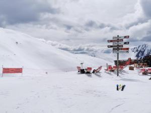 une piste de ski enneigée avec des panneaux sur une montagne dans l'établissement Appartement 4 personnes Les Orres 1800 au pied des pistes, aux Orres