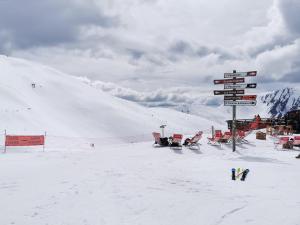 a snow covered ski slope with signs on a mountain at Appartement 4 personnes Les Orres 1800 au pied des pistes in Les Orres +1 photo