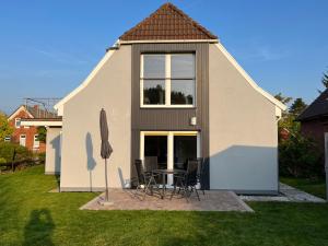 a house with a table and chairs in the yard at Bakker Huus DG in Emden